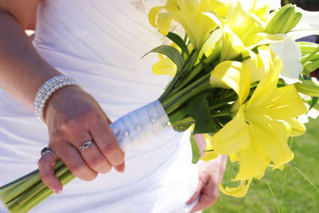 A closeup shot of a brides flower bouquet in her hands.の写真素材