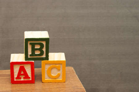 Alphabet blocks in front of the chalkboard for learning the basics of the english language.の写真素材