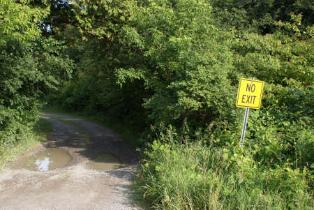 A bright yellow sign warns drivers that the road ahead has no exit.