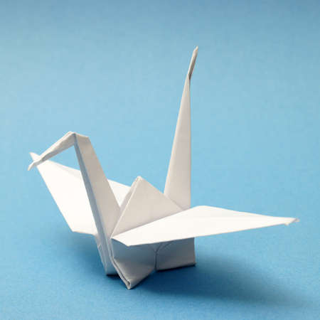 A nicely folded origami swan over a blue tranquil background.の写真素材