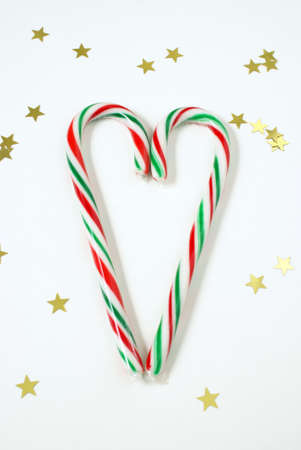 Two candy canes come together in the spirit of the holidays to make a heart shape.
