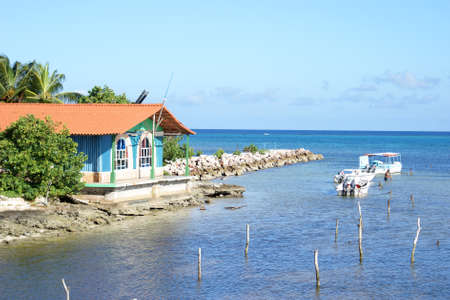 A fishing warf in Guardalavaca, Cuba, with a worker docking his boat.のeditorial素材