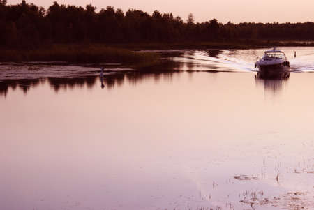 A boat chanels threw the river in the warmth of summer.の写真素材