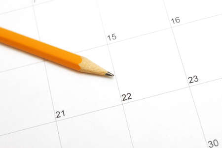 A sharpened pencil rests on a calendar for use in planning the days in the month.の写真素材