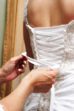 A bride to be is getting her dressed tied before her big moment of marriage.の写真素材
