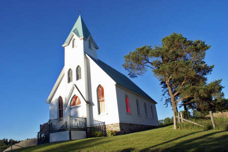 A lovely composition of a white church in the charming countryside.