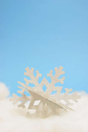 A closeup view of a decorative winter snowflake over a blue background.の写真素材