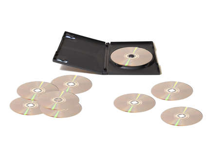A DVD collection with scattered disks over a white table.