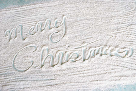 A festive Christmas greeting is wrote in the flour during the holiday baking in the kitchen.