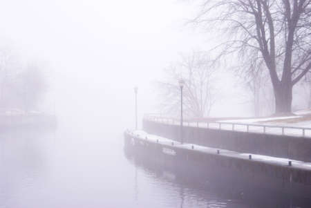 One frame of a series of images produced to emphasize the emotional and dramatic effects of the mist setting on the river bed in a local town during the seasonal changes into the early springtime.の写真素材