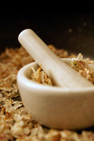 A vertical orientation of a mortar and pestle ready for preparing some dried Apple Blossoms into herbals for medical uses.の写真素材