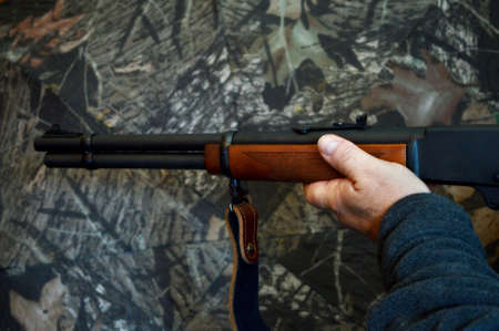 A man holds his rifle in full aim to shoot.の写真素材