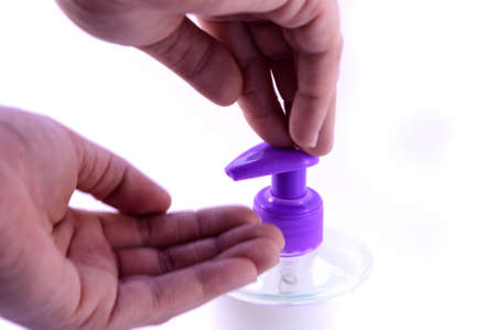 A person uses a hand pump soap dispenser to clean the hands.