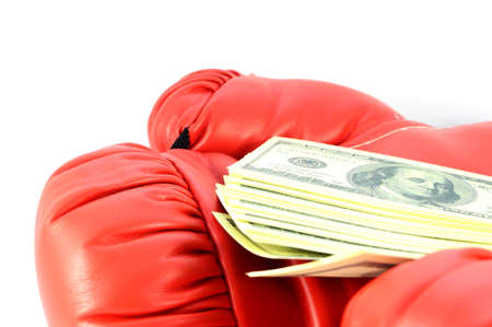 A closeup view of red boxing gloves holding the cash winnings of a bet made on the match sport.の写真素材