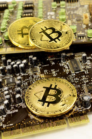 Closeup view of Bitcoins resting on top of a circuit board for showing the digital cryptocurrency...