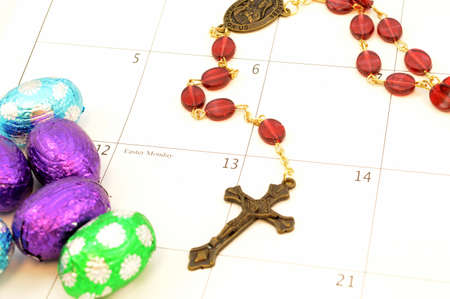 Easter Monday is marked on the calendar with a rosary and some chocolate eggs for the holiday season.の写真素材