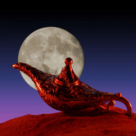 A magical genie lamp is revealed in the surface of the sand during the late hours of the evening.の写真素材