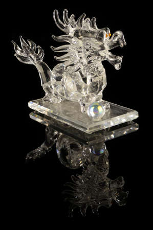 A lucky crystal dragon over a black reflective background.の写真素材