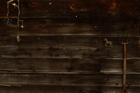 A closeup view of the side of an old barn with some tools and trinkets.の写真素材