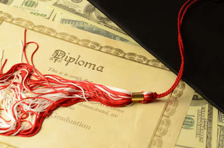 A closeup of a diploma certificate with a mortarboard and some American banknotes for the education...