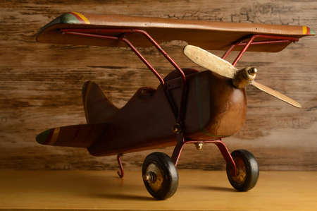 A closeup view of a childs toy wooden airplane resting on a shelf.の写真素材