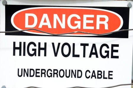 A closeup image of a high voltage warning signage claiming a dangerous zone.の写真素材