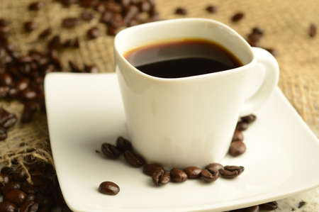 A single cup of espresso in an aromatic roasted coffee bean scene.の写真素材