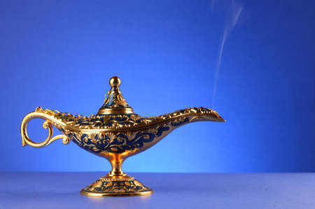 A magical lamp with a smoke trail over a blue gradient background.の写真素材