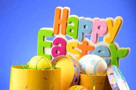 A festive holiday scene with the words saying Happy Easter over a blue background.の写真素材