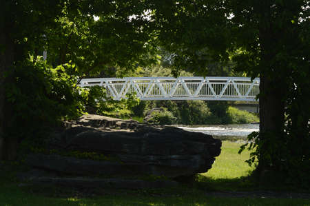 A beautiful walking bridge shown framed thru the trees at Turtle Island, Smiths Falls, Ontario during the springtime.の写真素材