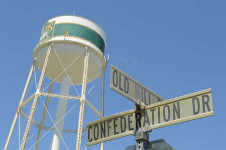 SMITHS FALLS, ONTARIO, CA, JUNE 16, 2021: An intersection sign of Old Mill Road and Confederation Drive located in Smiths Falls, Ontario with the towns water tower in the background.のeditorial素材