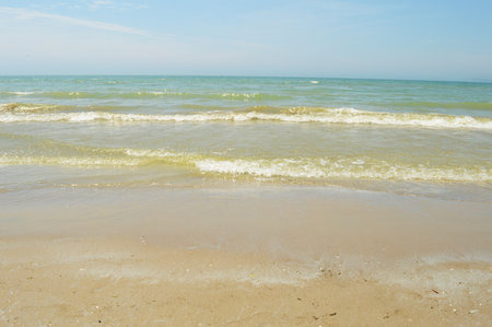A view of the waters edge looking out from the shoreline to the horizon above the water.の写真素材