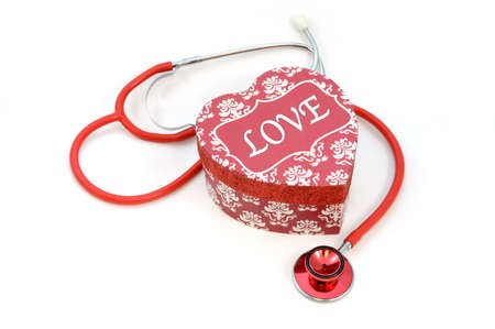 A stethoscope of love concept using a red gift box over a white background.の写真素材