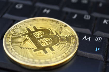 A commemorative Bitcoin ontop of a black computer keyboard to conceptualize on the cryptocurrency and digital aspects.の写真素材