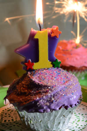 A lit candle on a cupcake to celebrate the first year whether a birthday or event.の写真素材