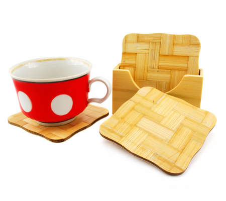 Colored cup and set of wooden trivets isolated on a white backgroundの写真素材