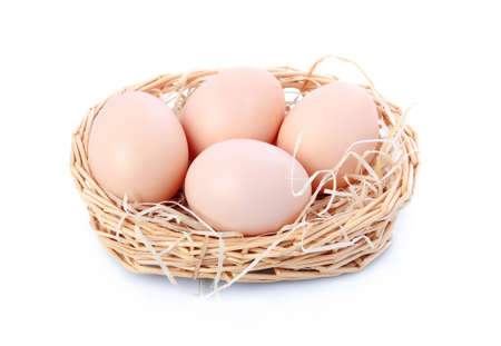Raw eggs in basket isolated on white backgroundの写真素材