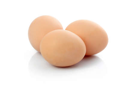 Three brown raw eggs isolated on white background