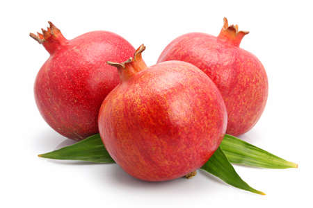 Pomegranate fruits with green leaf isolated on white background の写真素材