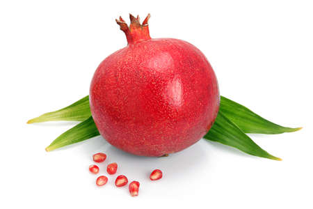 Pomegranate fruit with green leaf and seeds isolated on white background の写真素材
