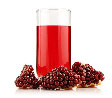Glass of  pomegranate juice with sliced fruits isolated on white backgroundの写真素材