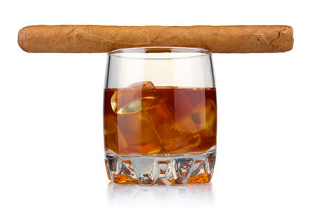 Glass of whiskey with ice cubes and havana cigar isolated on white backgroundの写真素材