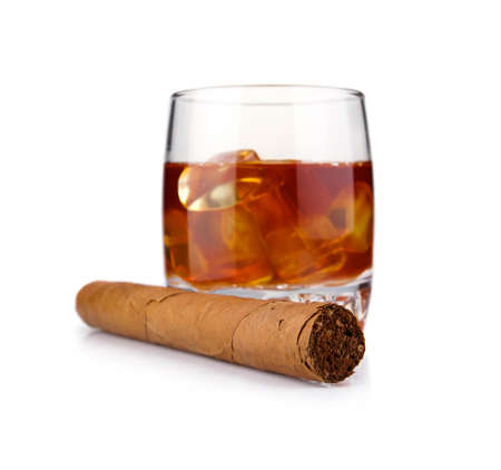 Glass of whiskey with ice cubes and havana cigar isolated on white backgroundの写真素材