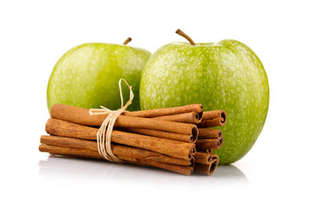 Ripe green apples with cinnamon sticks isolated on white backgroundの写真素材