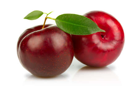 Ripe plums fruits with green leaves isolated on white backgroundの写真素材