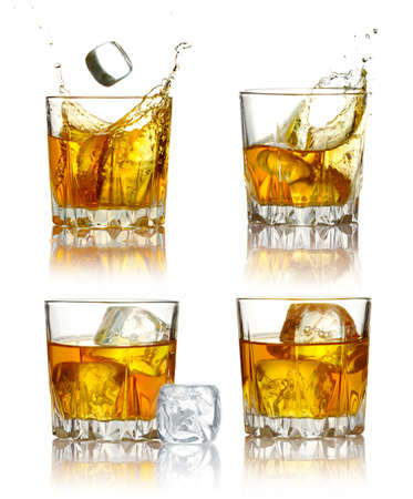 Set of scotch whiskey glasses with splash and ice isolated on a whiteの写真素材