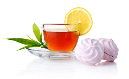 Cup of black tea with lemon, green leaves and marshmallow isolated on white backgroundの写真素材