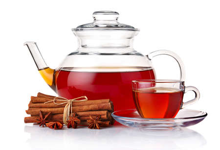 Glass teapot and cup of tea with spices isolated on white backgroundの写真素材