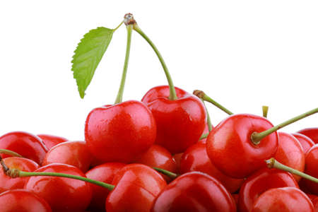 Heap of fresh cherry berries with green leaf isolated on white background の写真素材