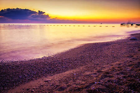 Beautiful landscape. Ocean beach during colorful sunset.の写真素材